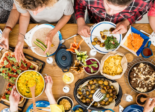 groupe de personnes déjeunant autour d'une table pleine de nourriture
