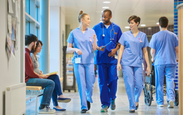 Groupe de médecins marchant et discutant dans le couloir d’un hôpital