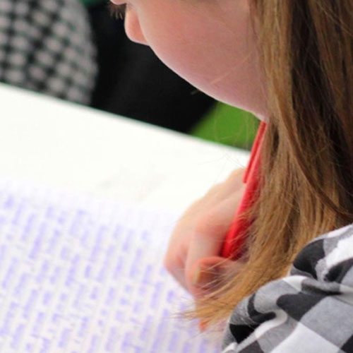 Une écolière en train d'écrire dans son cahier