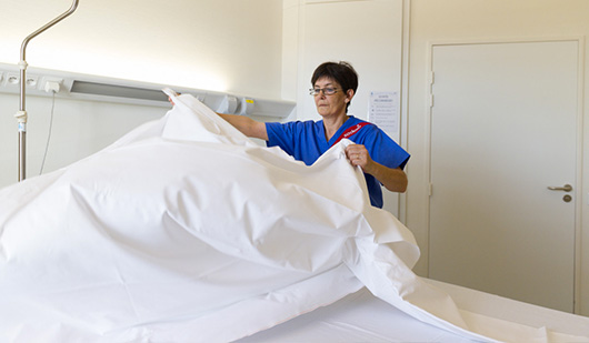 Infirmière en train de refaire un lit d’hôpital
